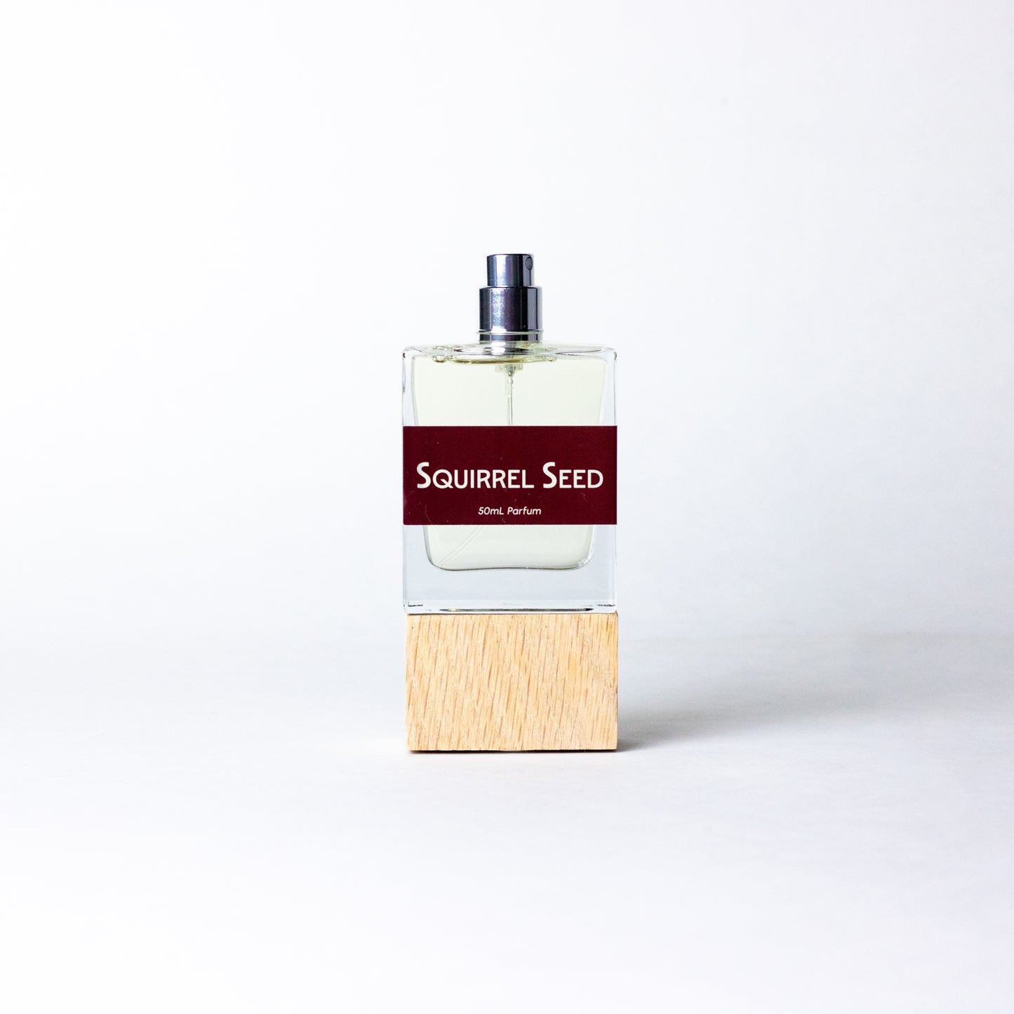 Squirrel Seed by DRYF, a handcrafted unisex fragrance with notes of ginger, lime, pomegranate, deep resins, woods, and musk, inspired by woodland adventures.